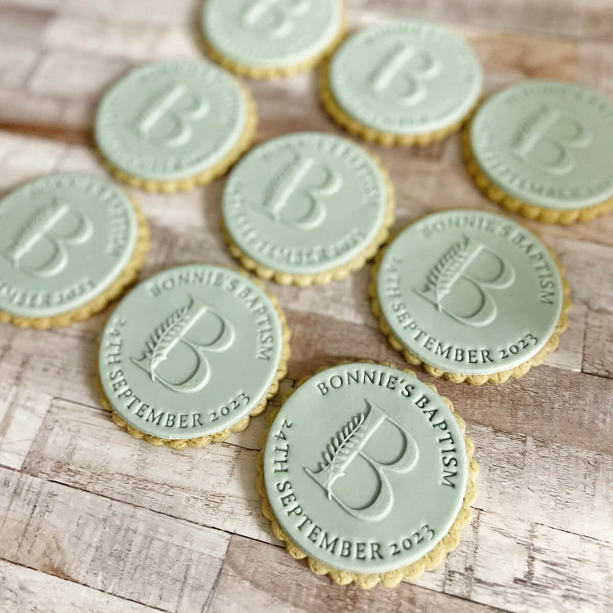 Green cookies with personalized embossing on a wooden surface