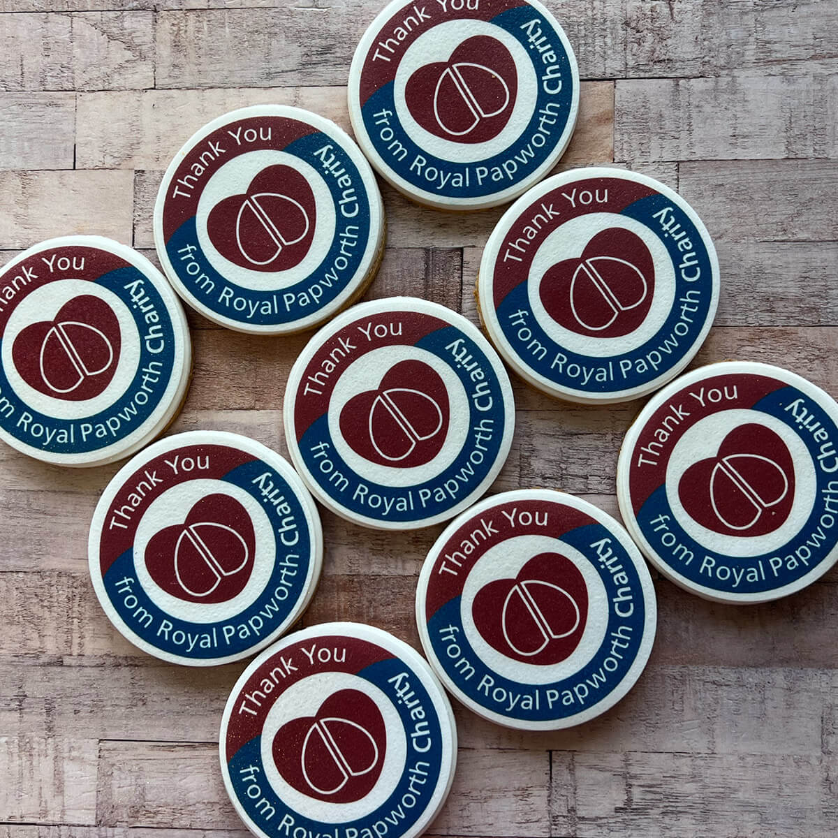 Circular stickers with a logo and text on a wooden surface