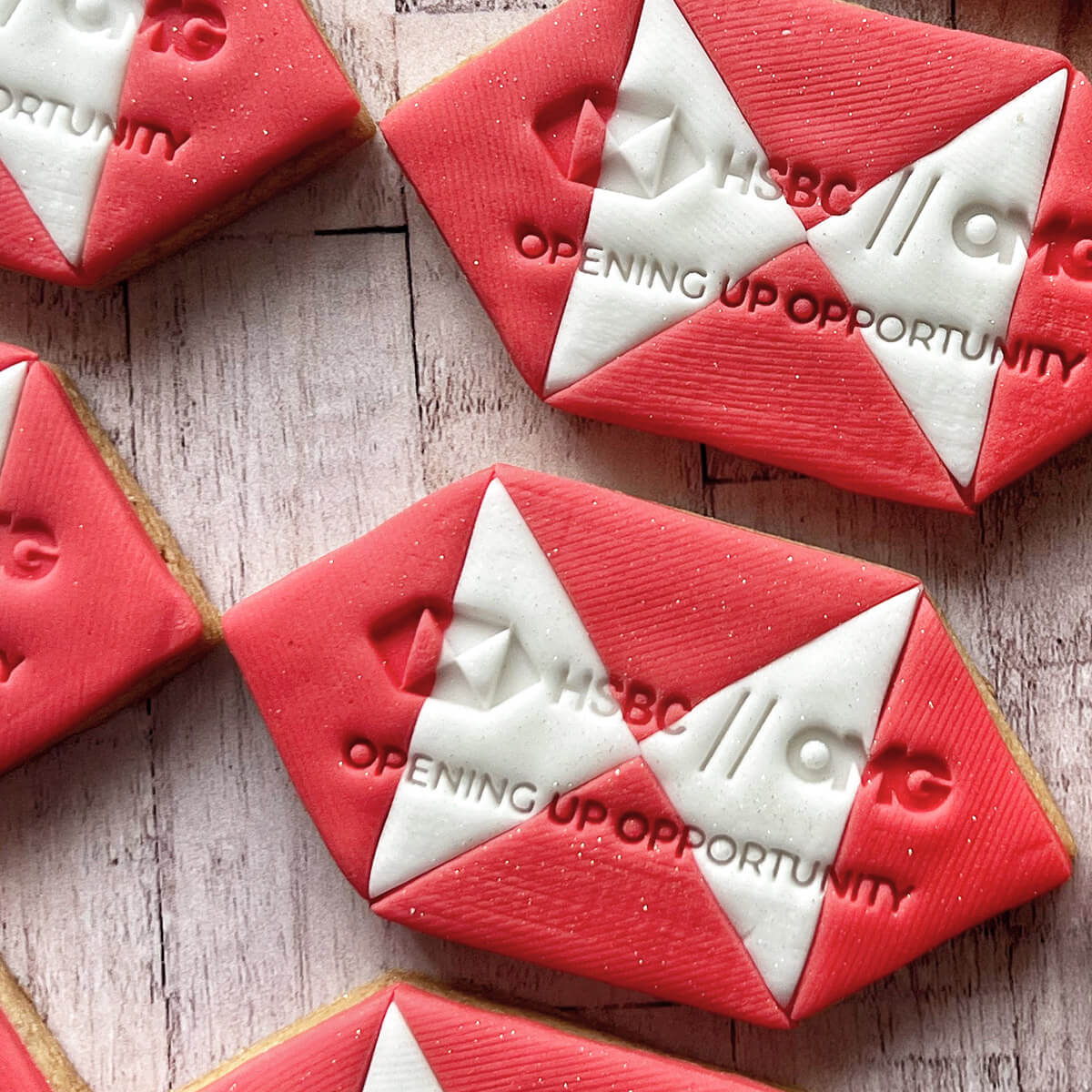Red and white cookies with HSBC branding on a wooden surface