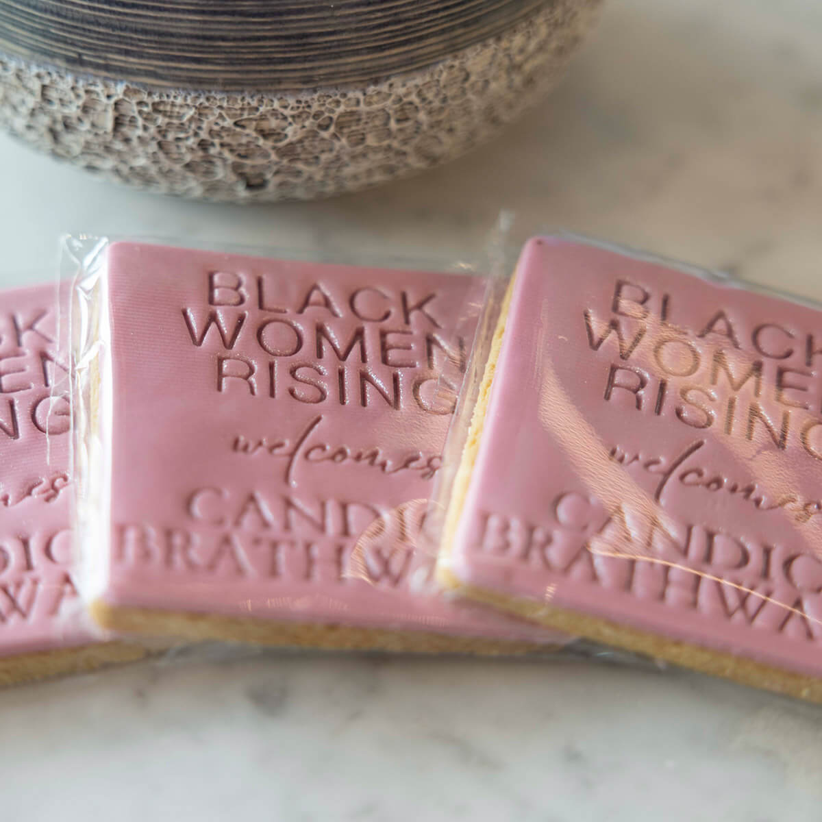 Pink soap bars with 'Black Women Rising' text on a marble surface