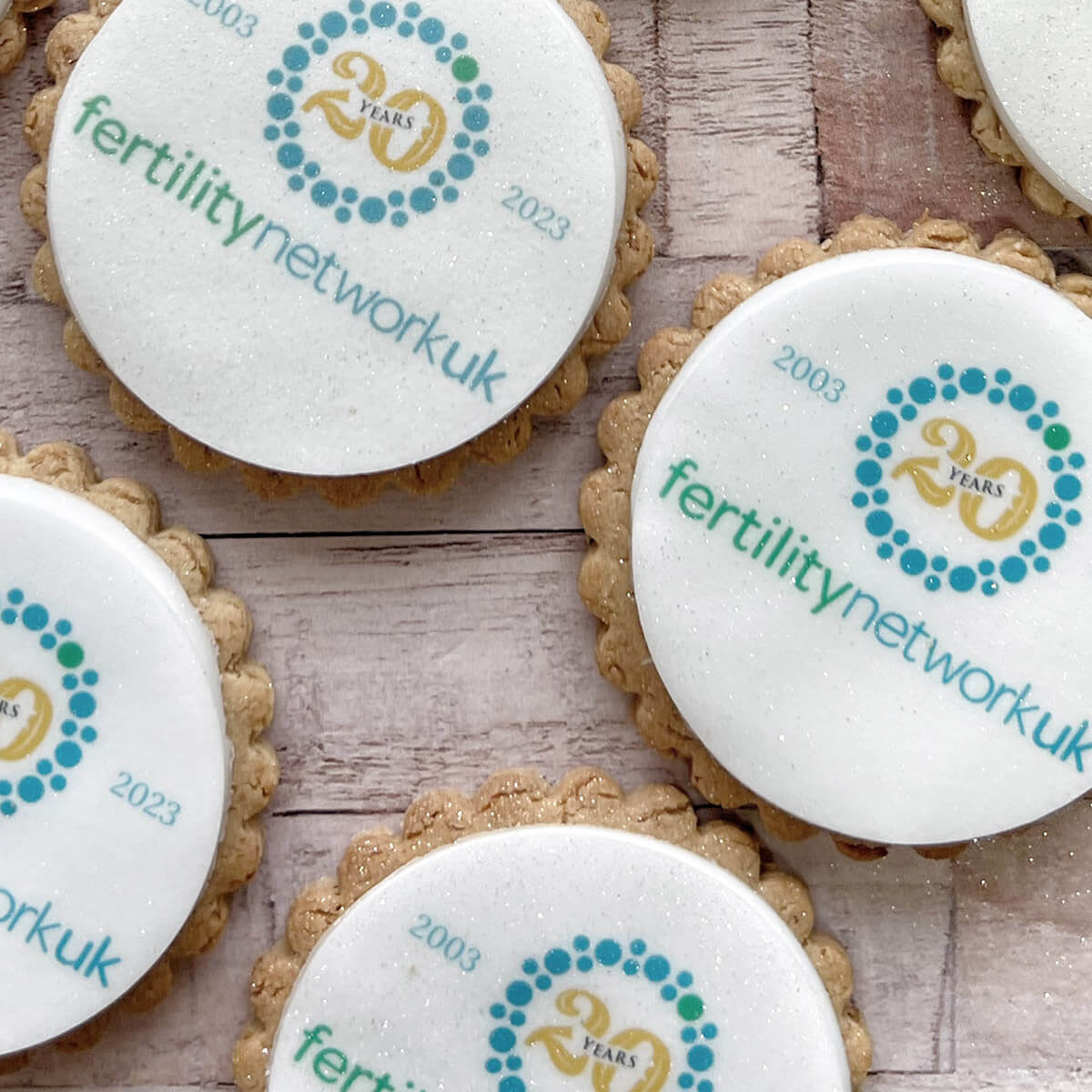 Cookies with 'fertilitynetworkuk' branding on a wooden surface