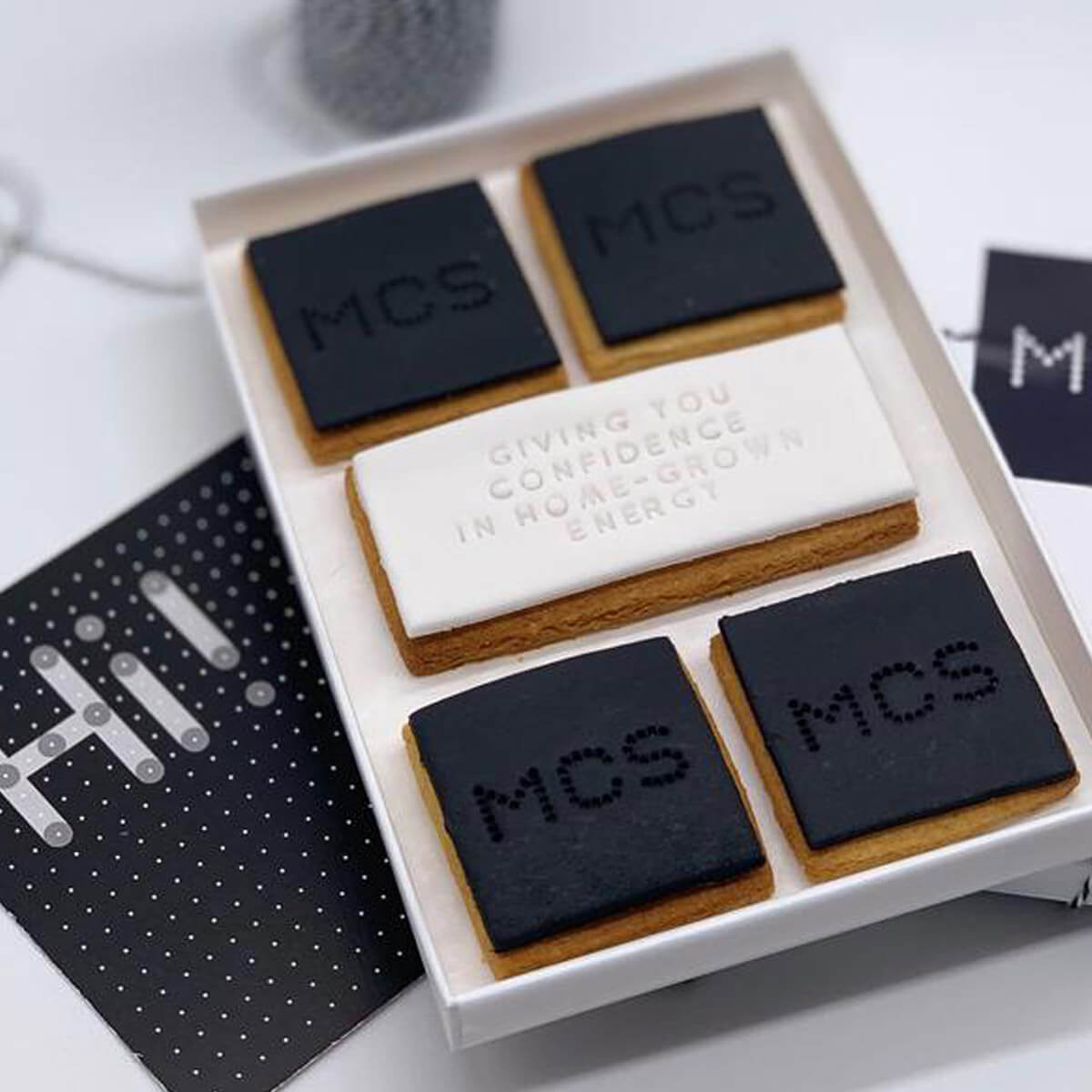 Set of branded coasters with 'MCS' and motivational text on a white surface.