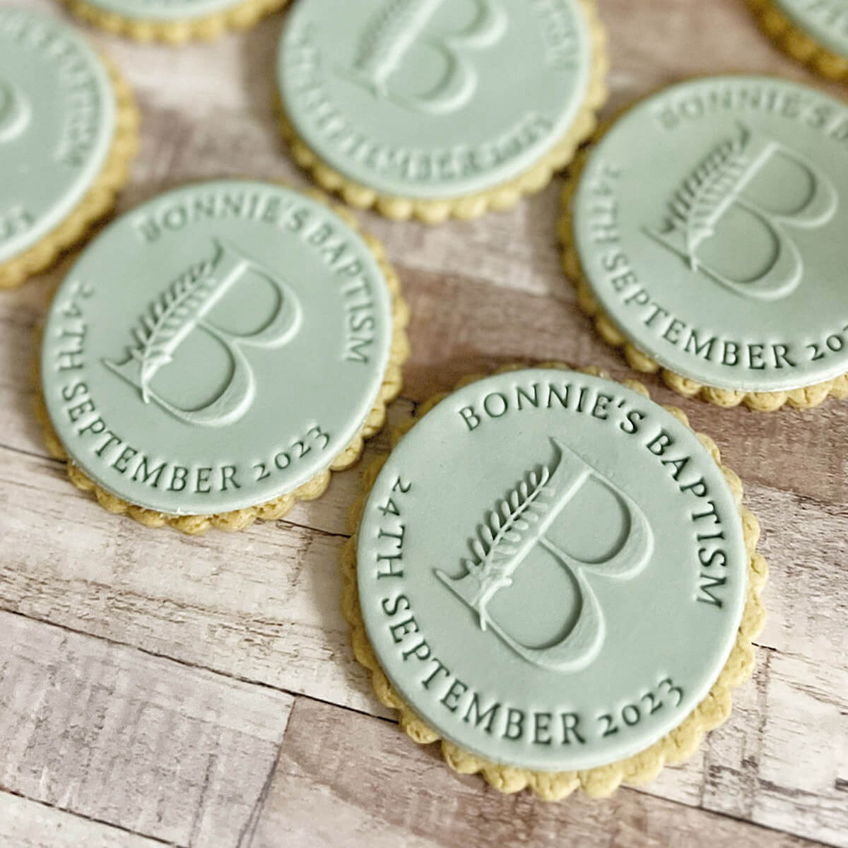 Cookies with personalized embossed designs on a wooden surface