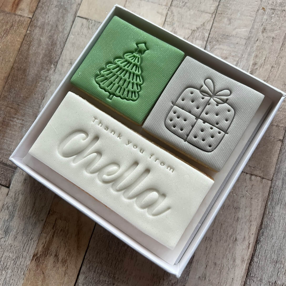 Three soap bars with embossed designs and 'Thank you from Chella' text in a box on a wooden surface.
