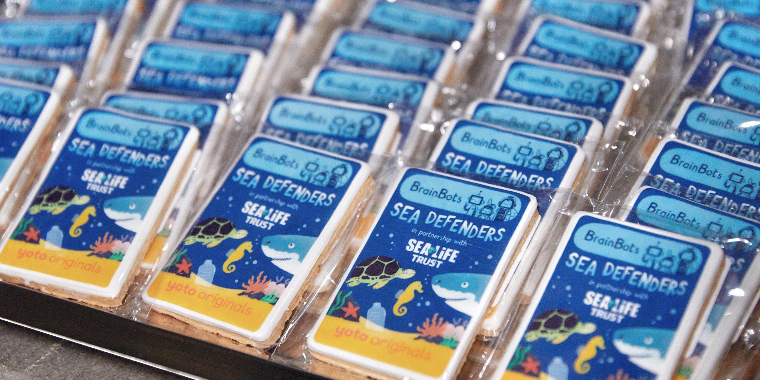 Packaged snacks with 'Sea Defenders' branding on a tray